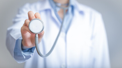 Doctor holds his stethoscope to insinuate that it's time for a check up, professional emergency...