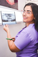 A female doctor showing a radiography x-ray. Una odontóloga mostrando una radiografía.	
