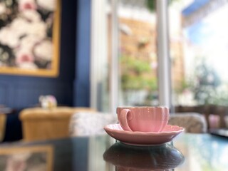 Blurred background focus on a pink vintage tea cup for afternoon tea. Fancy drinkware.