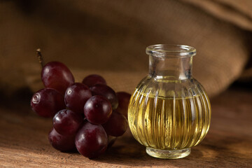 Grape seed oil and fruits on nature background.
