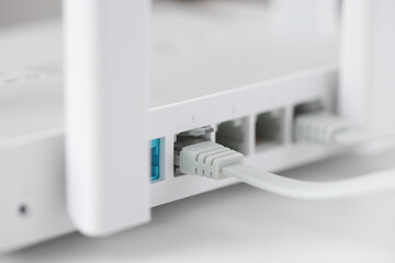 Network cable is plugged into socket of access point closeup - obrazy, fototapety, plakaty