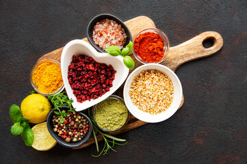 Dry seasonings and spices against a dark background view from the top.