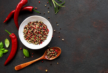 Red hot chili pepper corns and pods on dark  background, top view