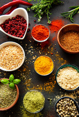 Colorful and aromatic herbs and spices on a dark background