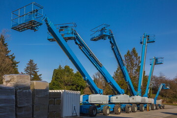 Construction machinery for rent. Lifts with raised platforms and are at the industrial court yard © Alex Lyubar