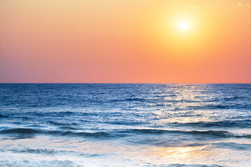 Obraz premium Beautiful sunset landscape, blue sea, ocean waves, tropical island beach, red orange sky, yellow sun glow, reflection on water, purple clouds, morning sunrise, peaceful dawn, seascape scenery, nature