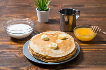 pancakes with jam, sour cream and honey on a wooden table