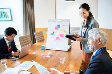 資料やコンピューターを確認する企画チームの社員たち