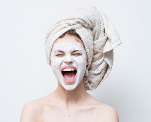 woman with towel on head cream mask nude shoulders skin care