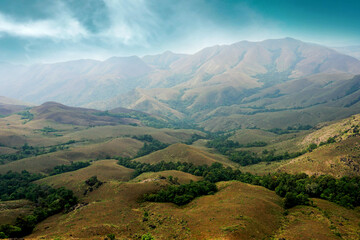 Fototapeta na wymiar Green valley and mountain range with moody sky 