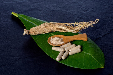 Ginseng ,powder and powder in capsule on black ceramic background.