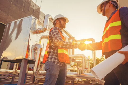 Architect and engineer construction workers consulting and discuss while working at cooling machine factory. Building construction collaboration concept	