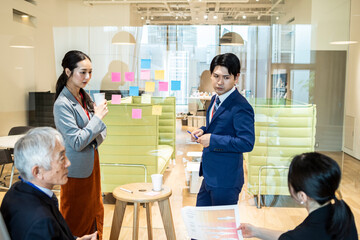 付箋にアイディアを書き出す企画チームの社員たち