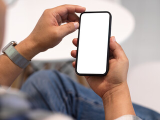 Man freelancer hands using smartphone with mock up screen in blurred background