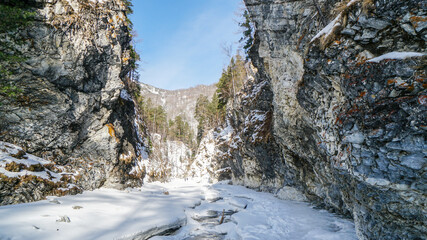 Fototapeta na wymiar Deep Gorge in Winter. River Canyon Covered with Snow