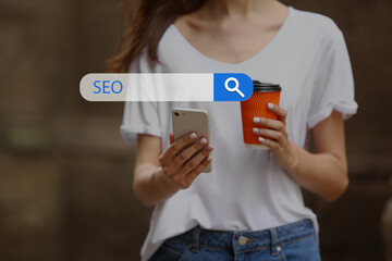 Young woman with mobile phone using web search engine outdoors