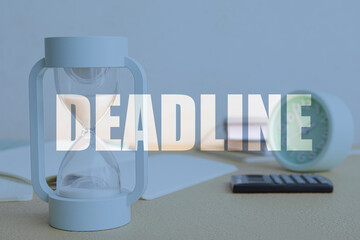 Double exposure of word DEADLINE and hourglass at workplace