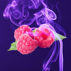 Tasty ripe raspberries and color smoke on dark background