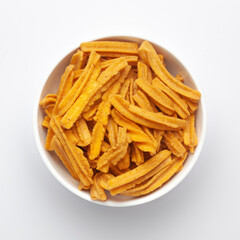 Close up of salted Soya Sticks Indian namkeen (snacks) on a ceramic white bowl. Top view