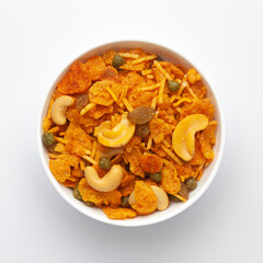 Close up of corn flex mixture Indian namkeen (snacks) on a ceramic white bowl. Top view
