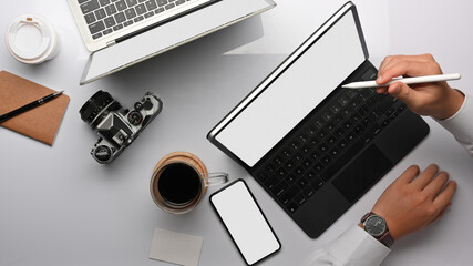 Top view of businessman hand working with tablet, smartphone and office supplies