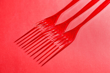 Plastic forks on color background
