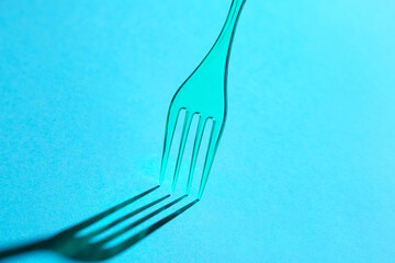 Plastic fork on color background