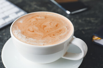 Cup of tasty latte on dark background, closeup