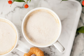 Cups of tasty latte on light background