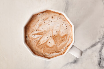 Cup of tasty latte on light background