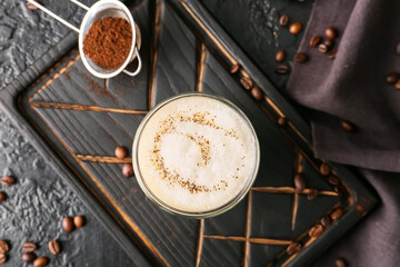Glass of tasty latte on dark background