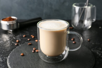 Glass cup of tasty latte on dark background