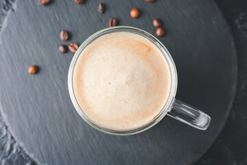 Glass cup of tasty latte on dark background