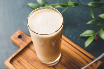 Glass of tasty latte on dark background