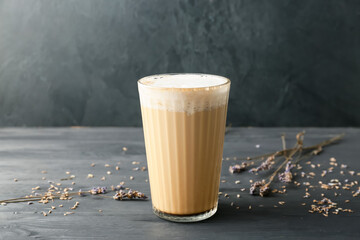 Glass of tasty latte on dark background