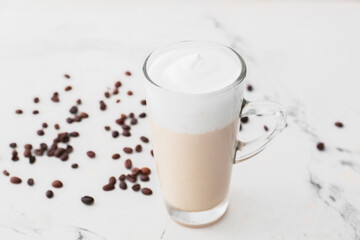 Glass cup of tasty latte on light background