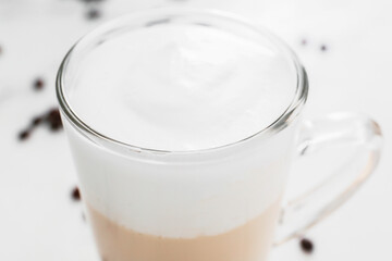 Glass cup of tasty latte on light background, closeup