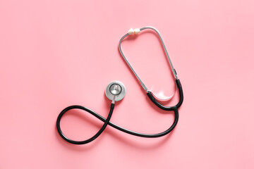 Modern stethoscope on color background