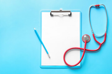 Stethoscope, clipboard and pencil on color background