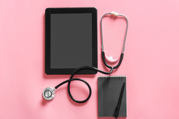 Stethoscope, notebook, tablet computer and pen on color background