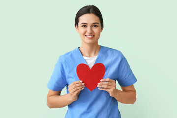 Cardiologist with red heart on color background