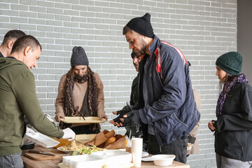 Volunteers giving food to homeless people in warming center