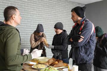 Volunteer giving food to homeless people in warming center