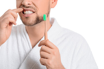 Man with aching teeth and tooth brush on white background