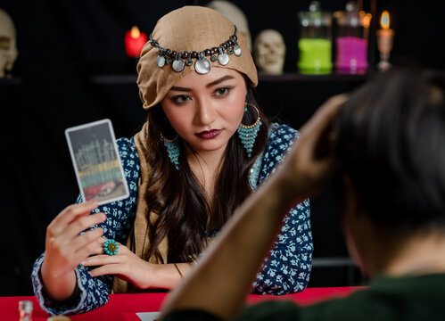 Asian fortune teller showing card to client