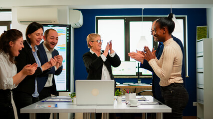 Motivated happy diverse business team people clapping celebrating success at corporate meeting. Multiethnical designers giving high five during corporate brainstorm receving good news enjoying victory