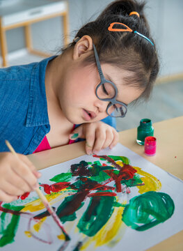 Asian girl with Down syndrome painting