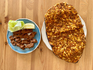 Turkish Kebab Lahmacun and Cig Kofte on Wooden Table Surface.