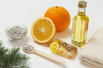 Cut orange with whole one, towel, bottle with aromatherapy oil and sea salt
