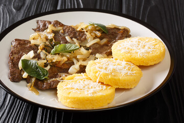Italian Venetian food beef liver with onion and sage, served with polenta close-up in a plate on the table. horizontal